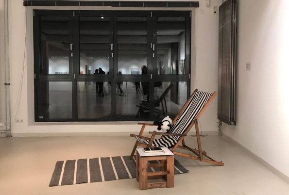 Installation eines gestreiften Liegestuhls auf Teppich vor Fenster