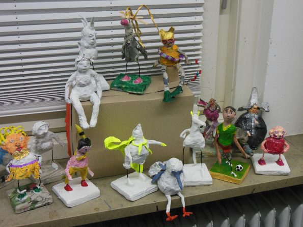 Ergebnisse aus dem Kurs Figuren aus Papiermaché, mehrere grundierte oder bemalte Figuren sitzen und stehen auf der Fensterbank